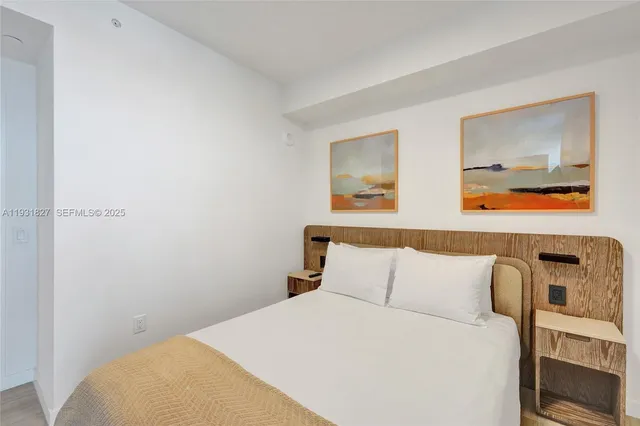 a bedroom with a bed and a view of kitchen