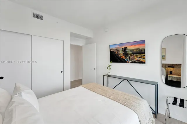 a large bed sitting in a bedroom next to a window