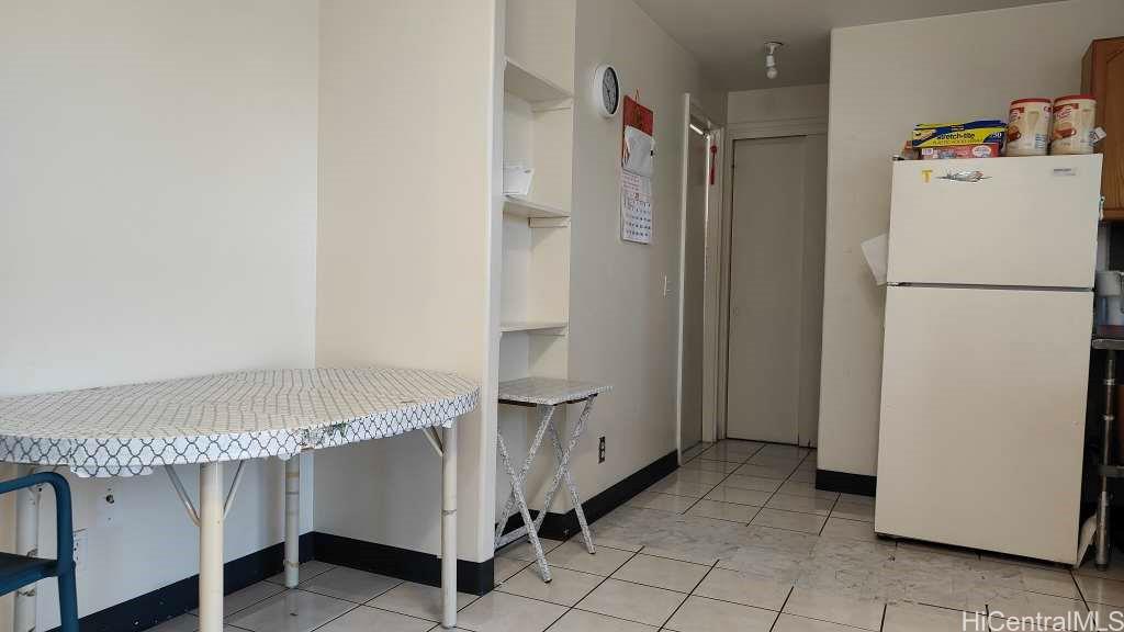 1325 North School Street, Unit C323 Honolulu, HI 96817 - Photo 4 of 11 a white refrigerator freezer and a table in a kitchen