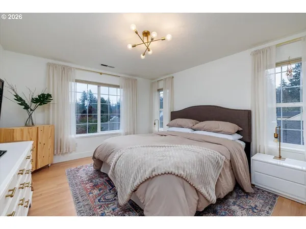a bedroom with a large bed and a chandelier