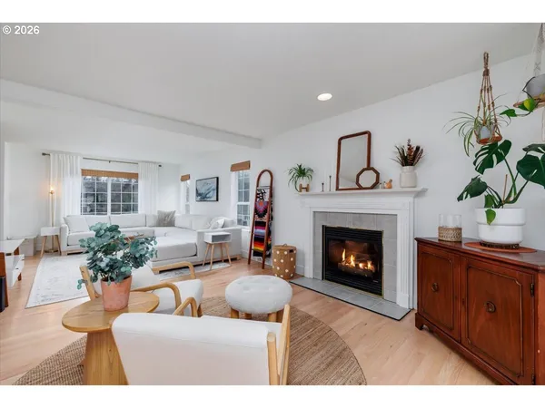 a living room with furniture a fireplace and a potted plant