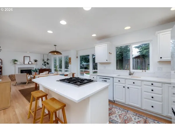 a kitchen with cabinets a sink a stove a dining table and chairs