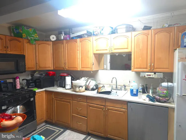 a kitchen with a sink appliances cabinets and a potted plant