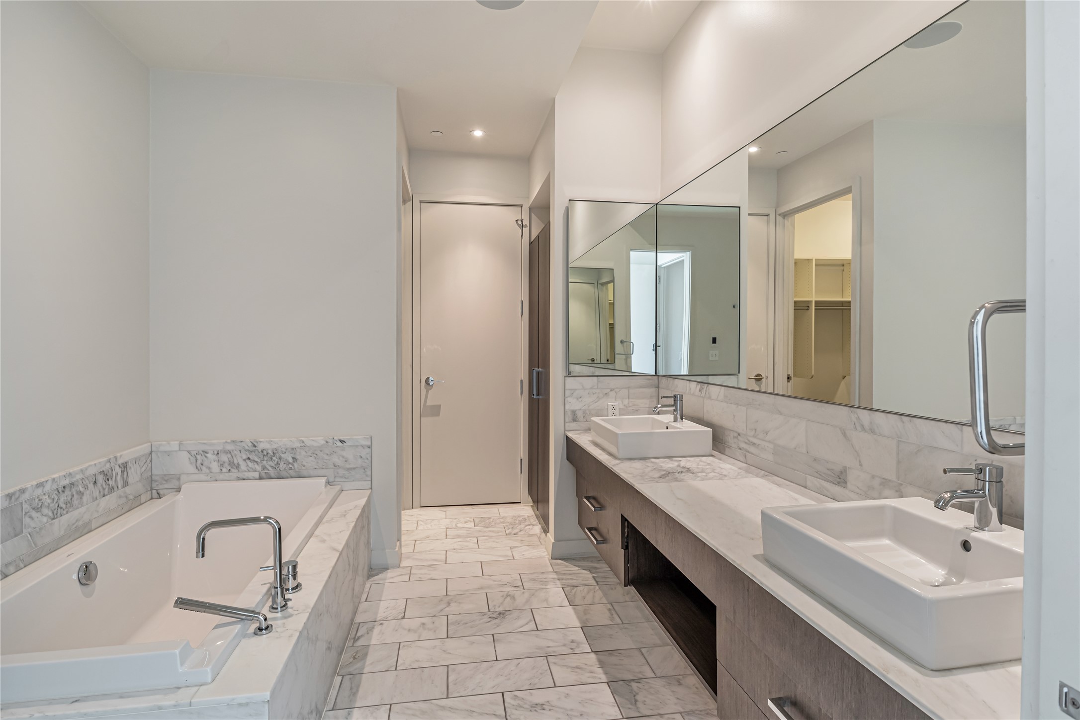 210 Lavaca Street, Unit 2903 Austin, TX 78701 - Photo 12 of 39 Bathroom featuring Carrara marble finish floor, a sink, tasteful backsplash, and a garden tub