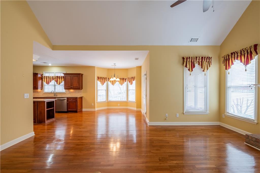 4924 Hugh Howell Road Stone Mountain, GA 30087 - Photo 11 of 42 a view of a big room with wooden floor a kitchen view and windows