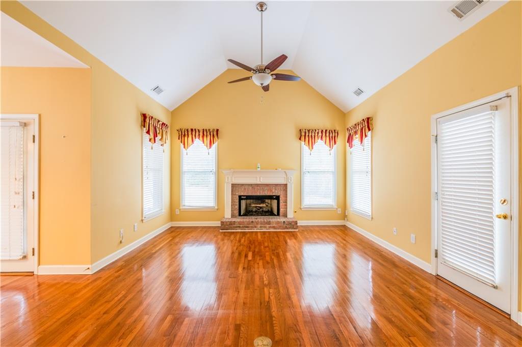 4924 Hugh Howell Road Stone Mountain, GA 30087 - Photo 13 of 42 a view of a livingroom with wooden floor a fireplace and windows