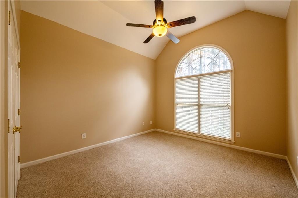 4924 Hugh Howell Road Stone Mountain, GA 30087 - Photo 18 of 42 an empty room with windows and fan