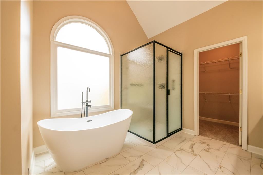 4924 Hugh Howell Road Stone Mountain, GA 30087 - Photo 24 of 42 a bathroom with a bathtub and a shower