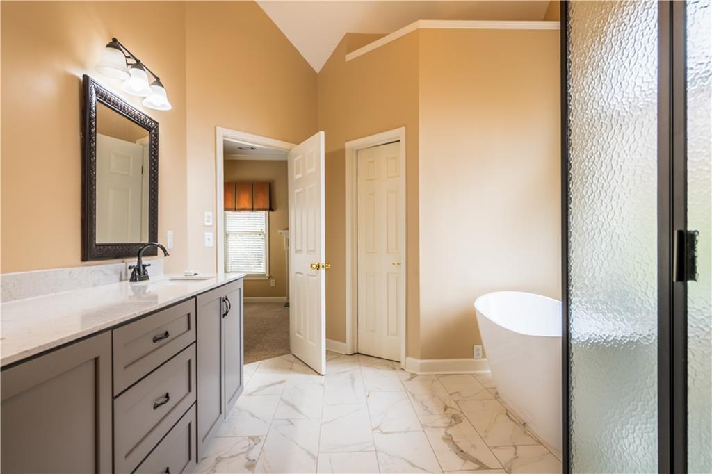 4924 Hugh Howell Road Stone Mountain, GA 30087 - Photo 26 of 42 a bathroom with a granite countertop sink toilet and shower