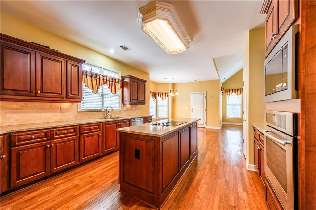 4924 Hugh Howell Road Stone Mountain, GA 30087 - Photo 9 of 42 a kitchen with stainless steel appliances granite countertop a stove and cabinets