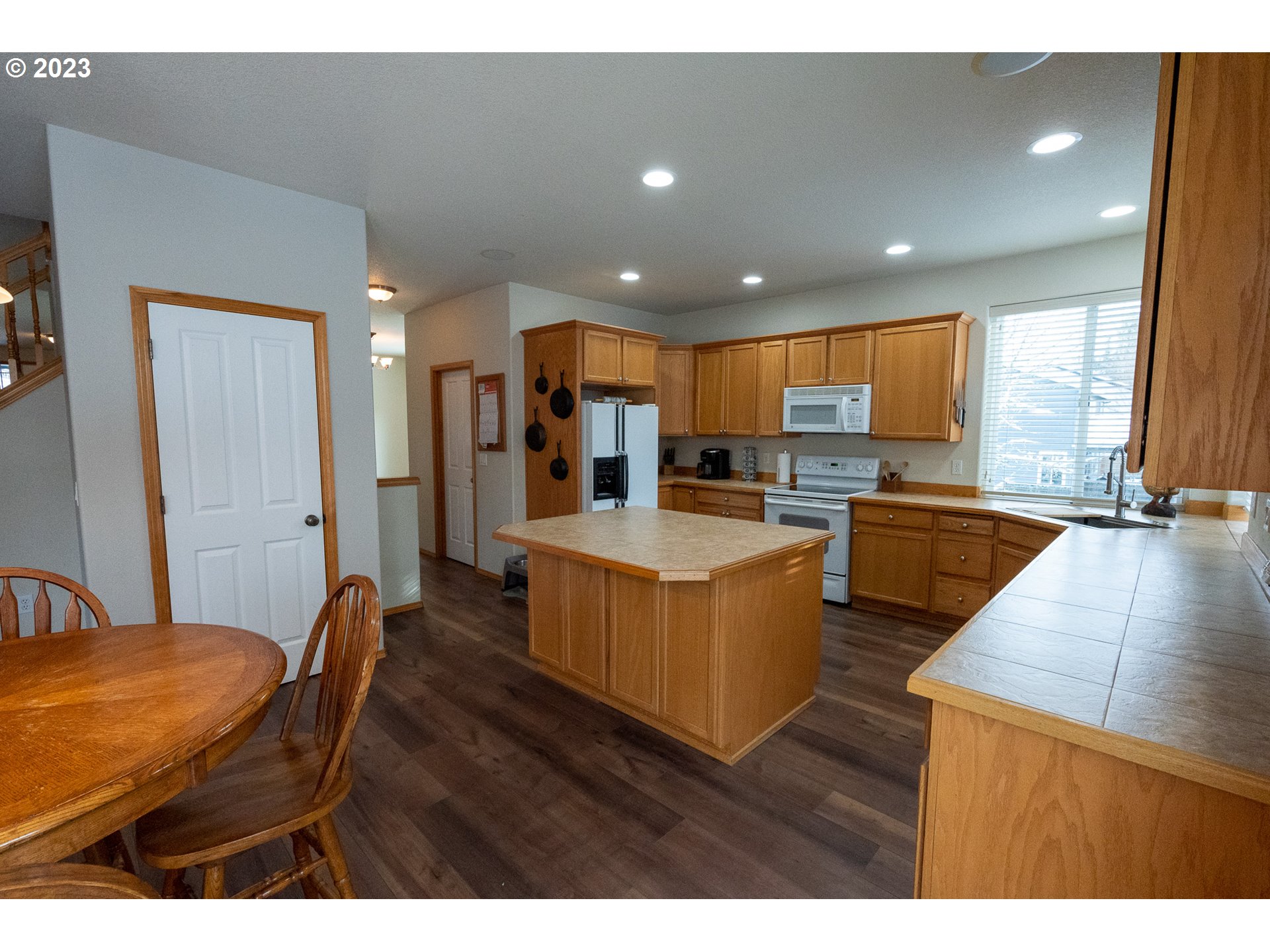 23891 Southwest Middleton Road Sherwood, OR 97140 - Photo 9 of 31 a living room with stainless steel appliances kitchen island granite countertop furniture wooden floor and a large window
