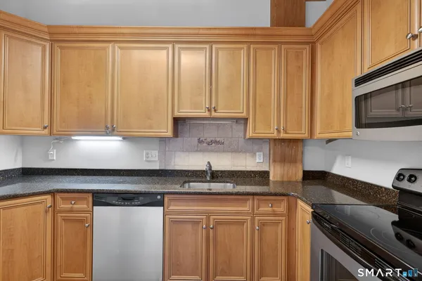 a view of a kitchen with a fridge and wooden floor