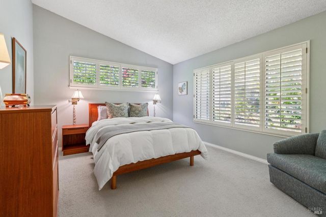 a bed sitting in a bedroom next to a window