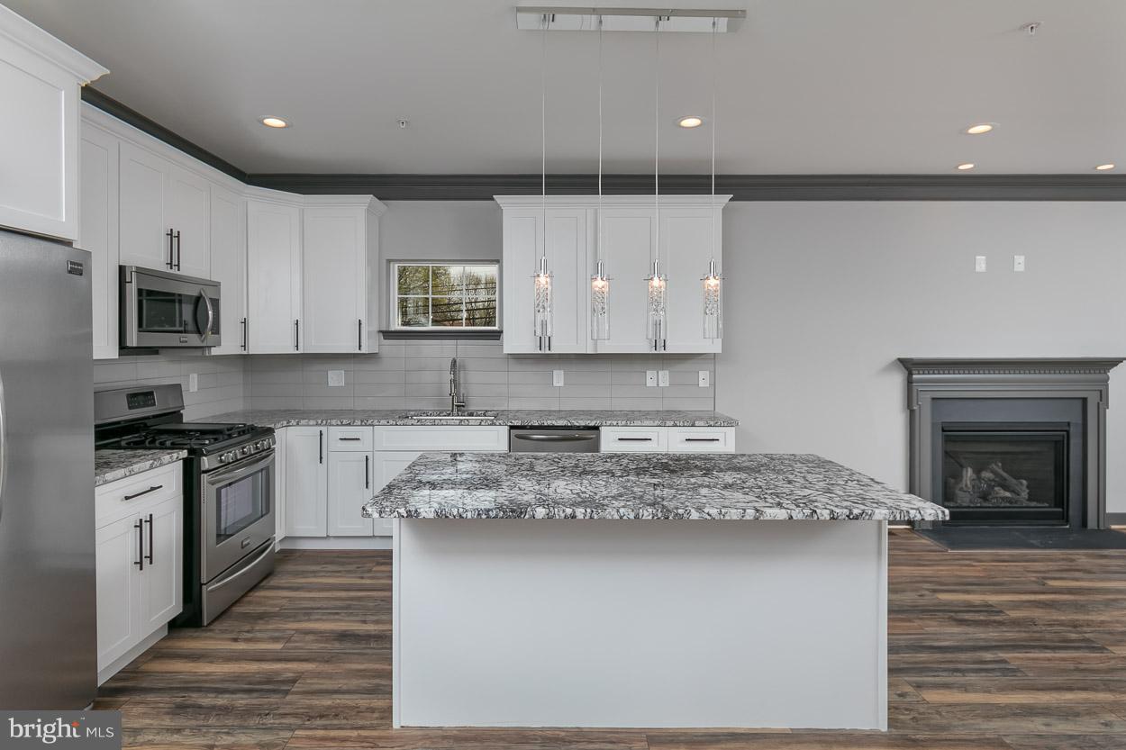 3601 Chapman Road Randallstown, MD 21133 - Photo 8 of 30 a kitchen with kitchen island granite countertop a stove a sink and a microwave