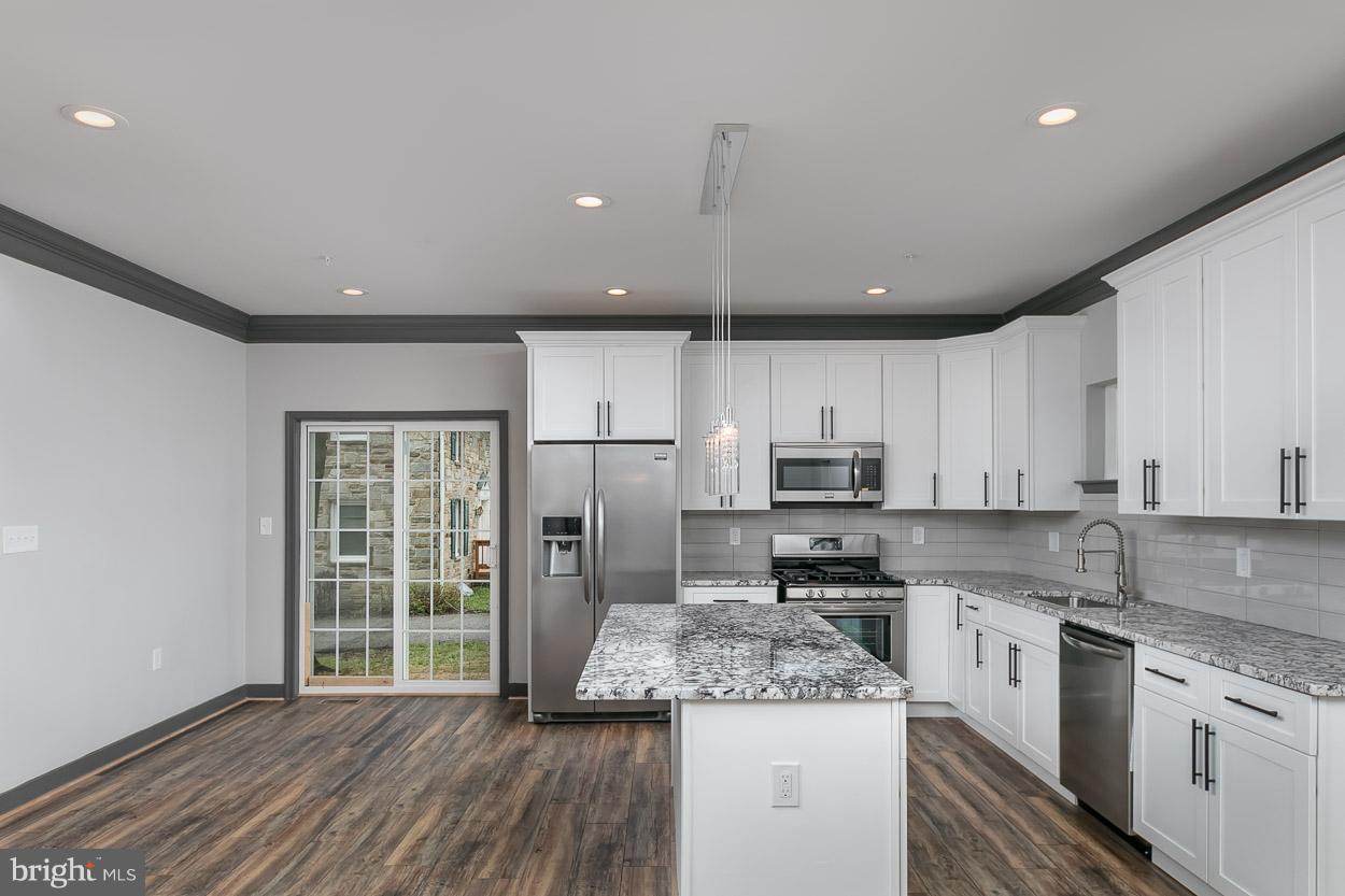 3601 Chapman Road Randallstown, MD 21133 - Photo 9 of 30 a kitchen with stainless steel appliances granite countertop a stove a sink dishwasher a refrigerator and white cabinets with wooden floor
