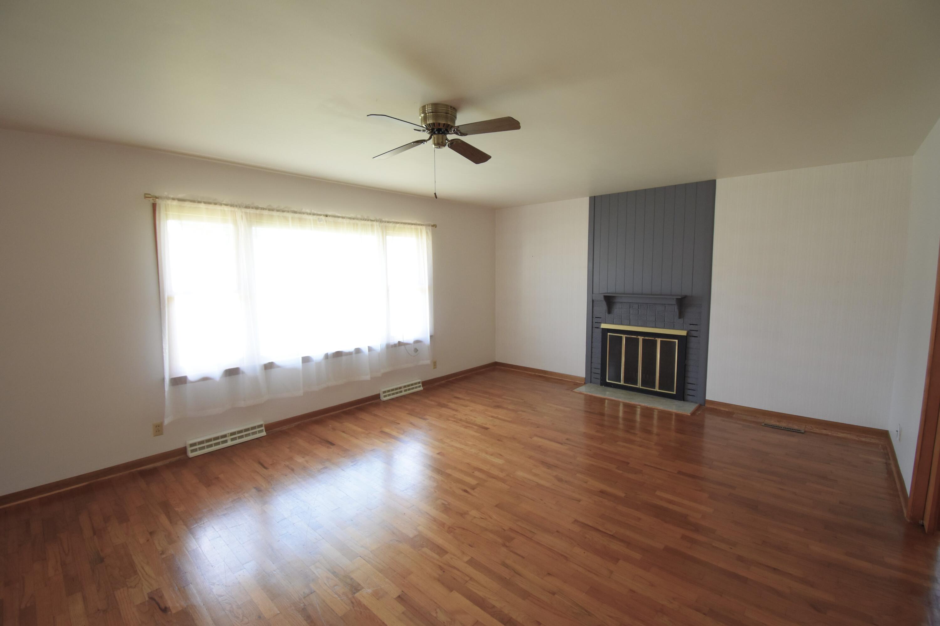 328 South Weston Street Rensselaer, IN 47978 - Photo 6 of 39 a view of an empty room with wooden floor and a window