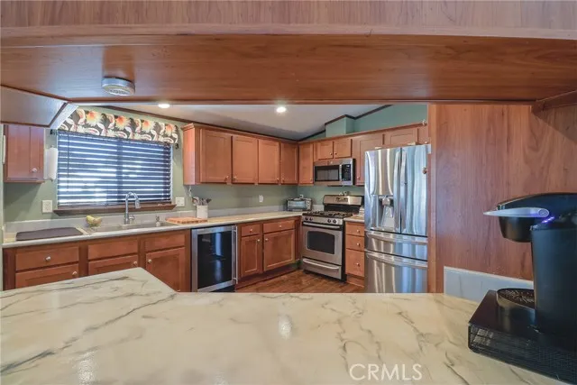 10550 Western, Unit 93 Stanton, CA 90680 - Photo 8 of 34 a kitchen with stainless steel appliances kitchen island granite countertop a refrigerator and stove