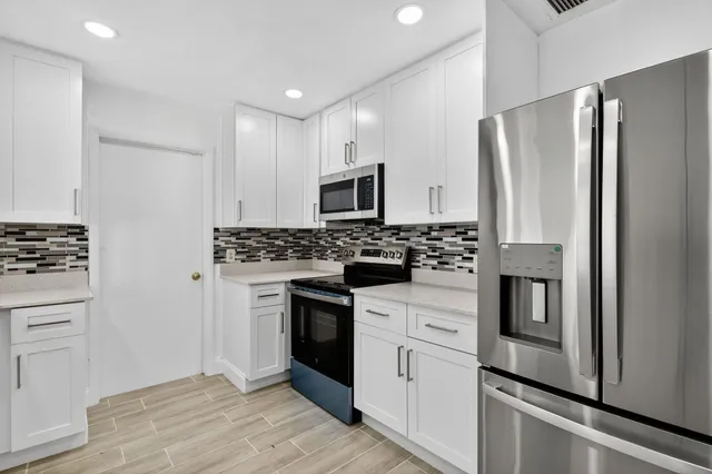 a kitchen with stainless steel appliances a stove a sink and a refrigerator