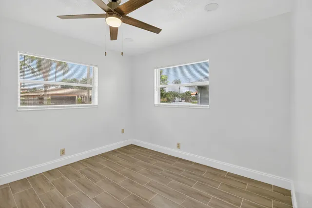 a view of an empty room with a window and a ceiling fan