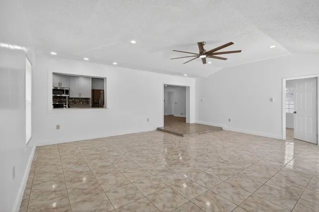 an empty room with windows and fan