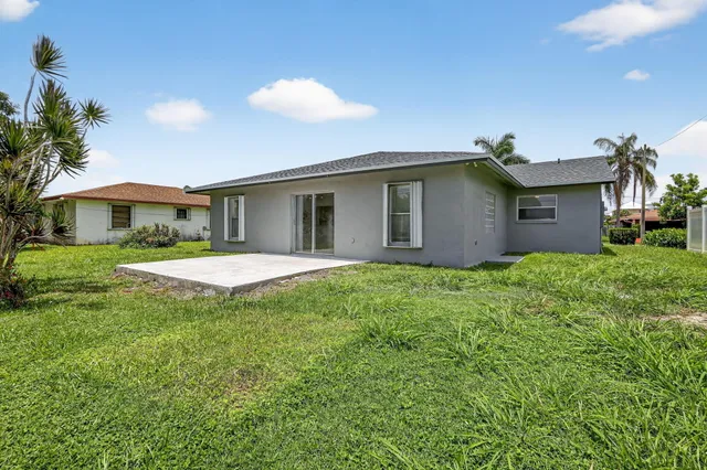 a view of a house with a yard and potted plants