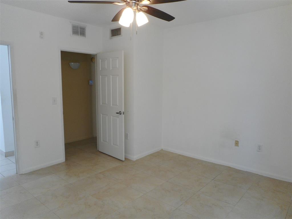 7970 North Nob Hill Road, Unit 207 Tamarac, FL 33321 - Photo 9 of 22 an empty room with a chandelier fan