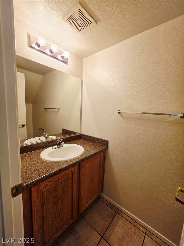 1571 Rusty Ridge Lane Henderson, NV 89002 - Photo 10 of 26 A well-appointed bathroom features a practical vanity with ample counter space and convenient under-sink storage.