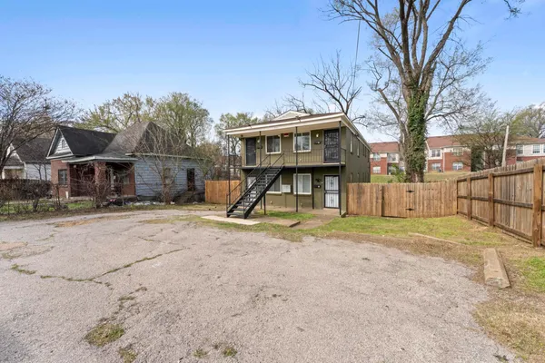 a view of a yard with wooden fence