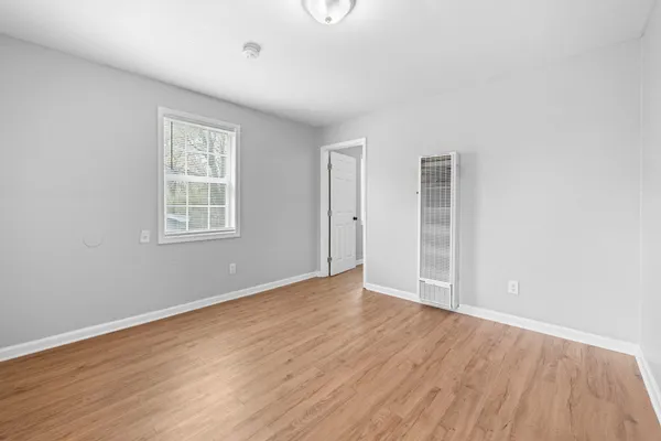 wooden floor in an empty room with a window