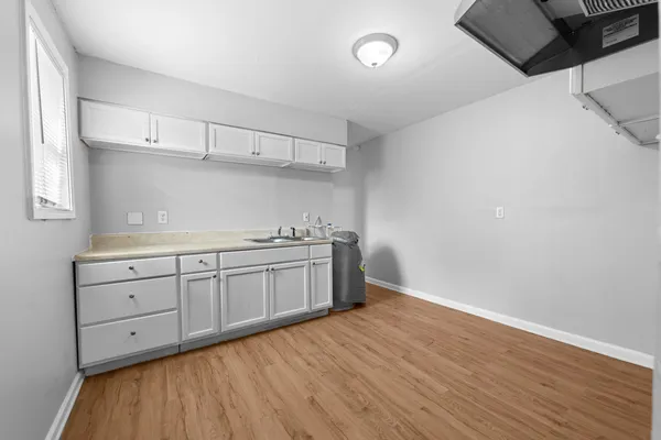 a kitchen with sink cabinets and wooden floor