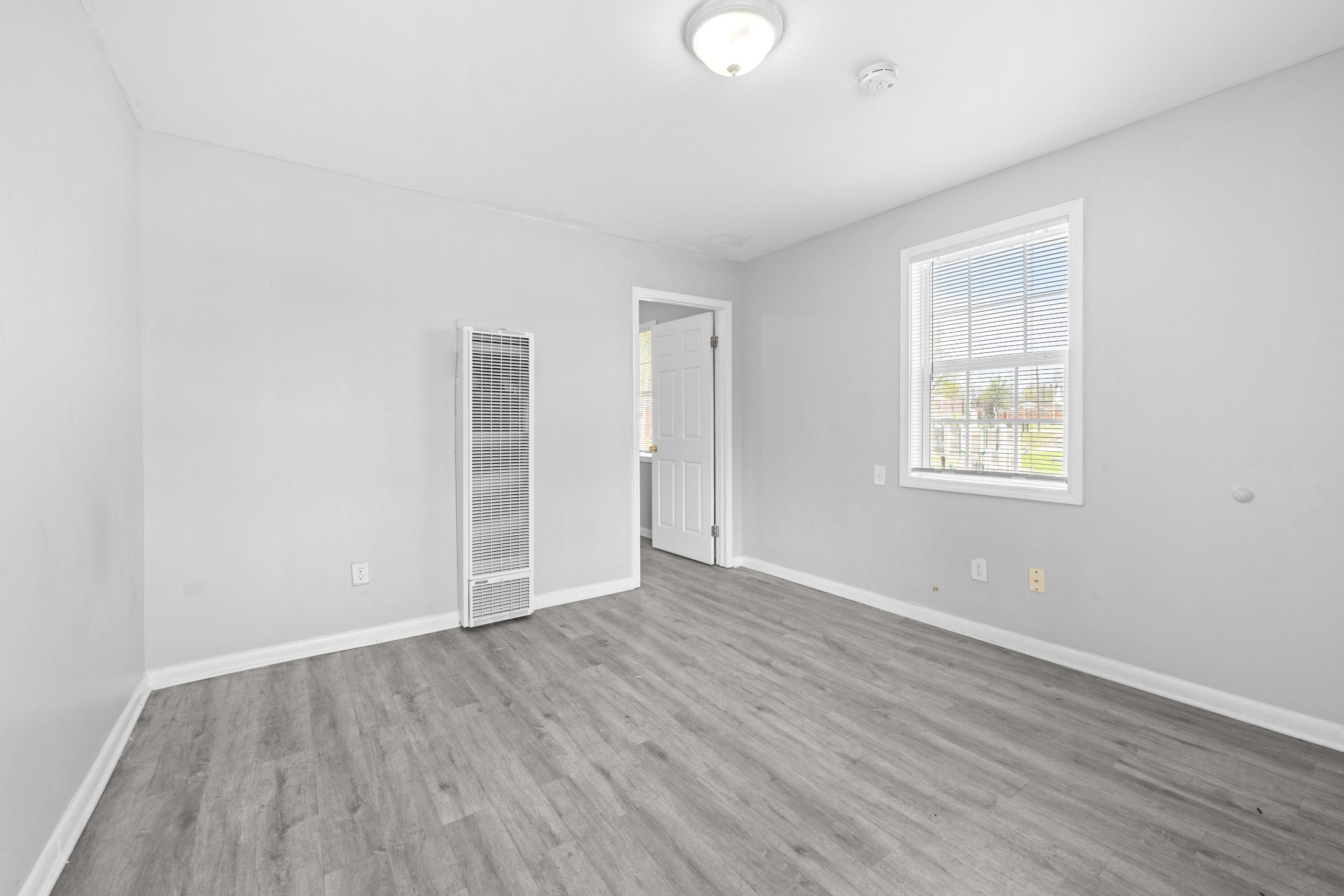 1493 Gaither Street Memphis, TN 38106 - Photo 7 of 27 an empty room with wooden floor and windows