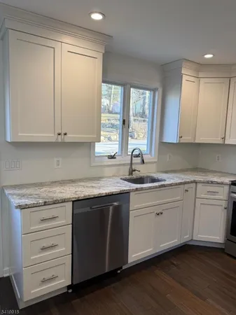 a kitchen with granite countertop cabinets sink and window