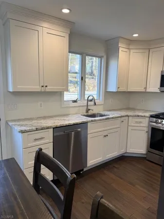 a kitchen with a sink cabinets appliances and a window