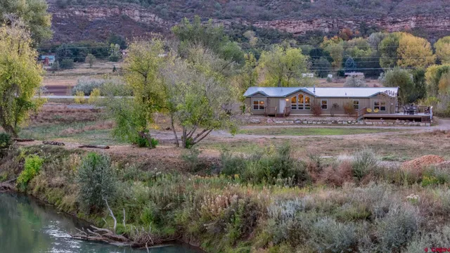 a view of a water house with a yard and large tree