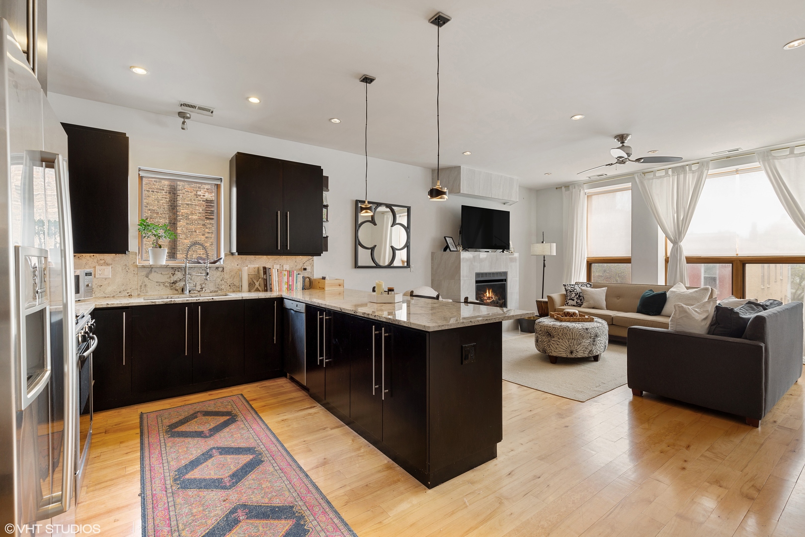 1842 North Damen Avenue, Unit 2N Chicago, IL 60647 - Photo 3 of 14 a large kitchen with kitchen island granite countertop a sink and a large refrigerator