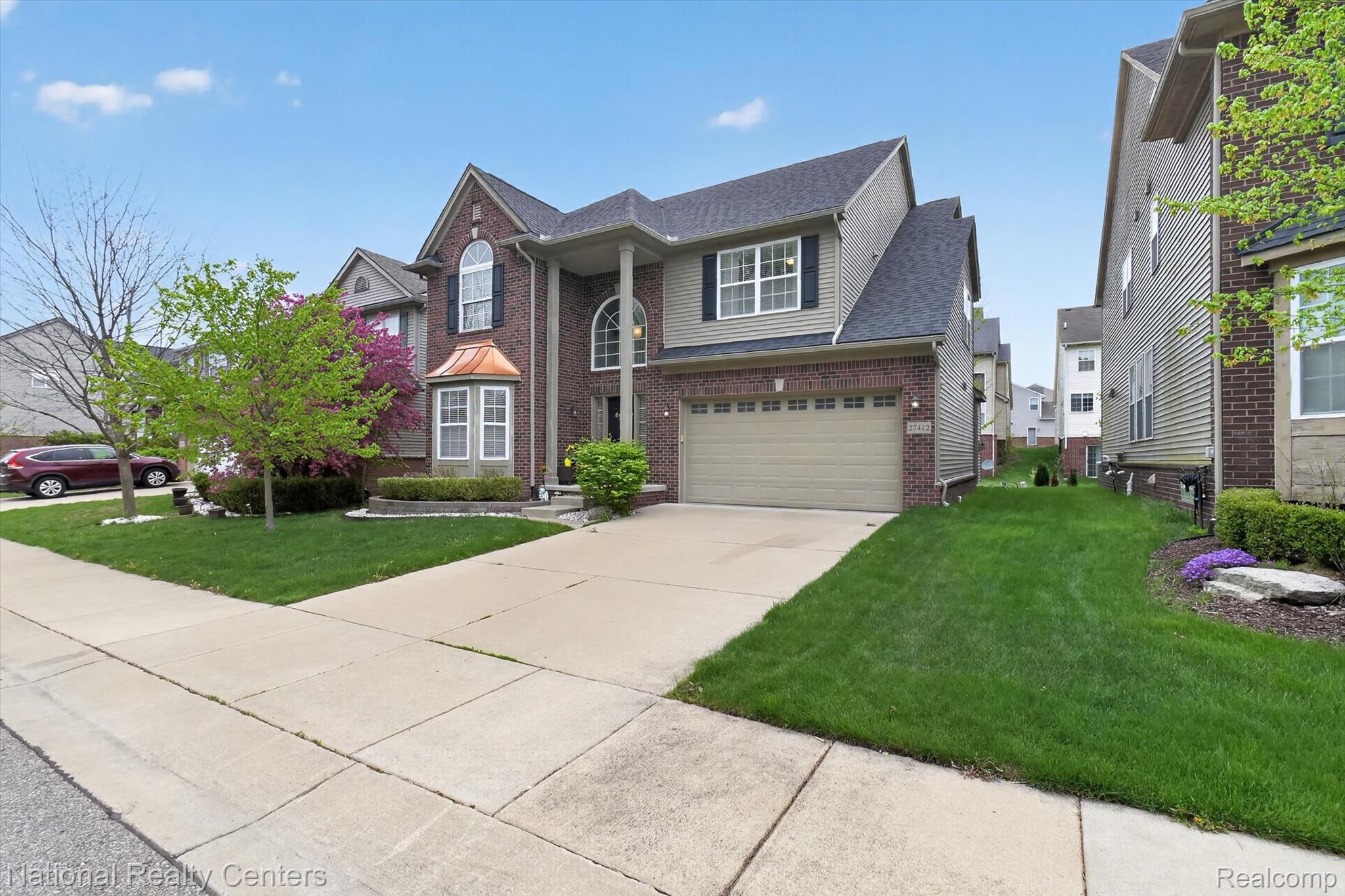 27412 Victoria Road Novi, MI 48374 - Photo 61 of 61 Two-story brick and siding residence featuring a two-car garage, established front landscaping, and a copper-toned bay window