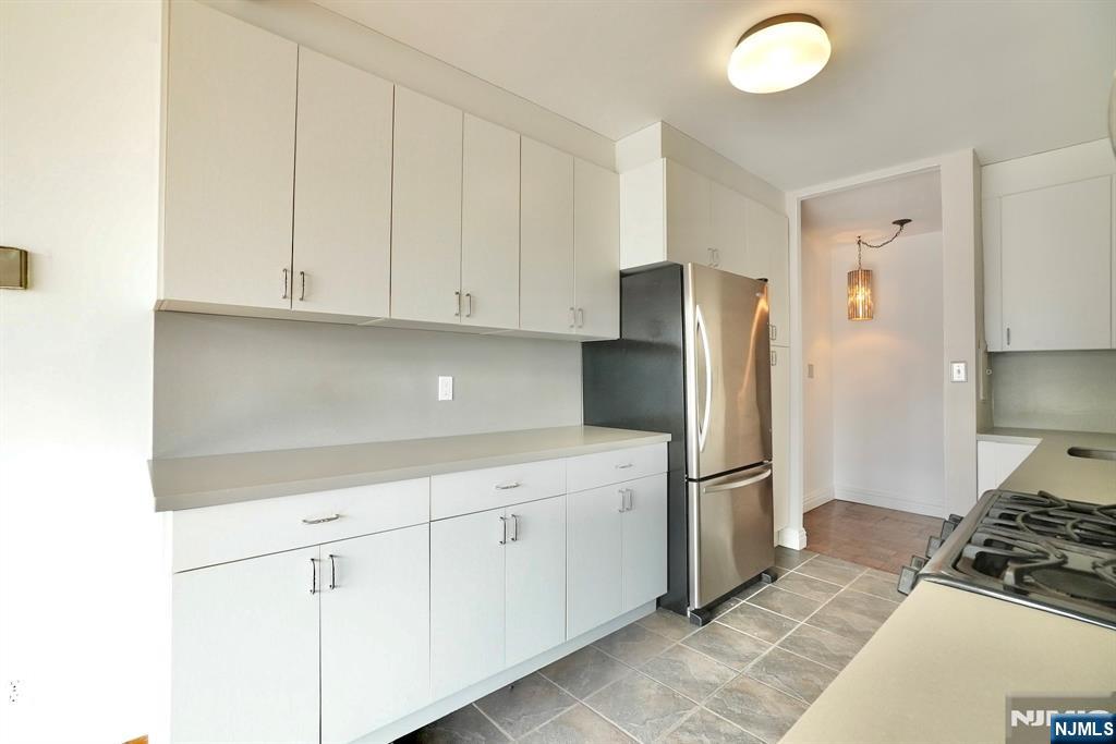 5 Horizon Road, Unit 203 Fort Lee, NJ 07024 - Photo 18 of 27 a kitchen with stainless steel appliances granite countertop a refrigerator and a stove
