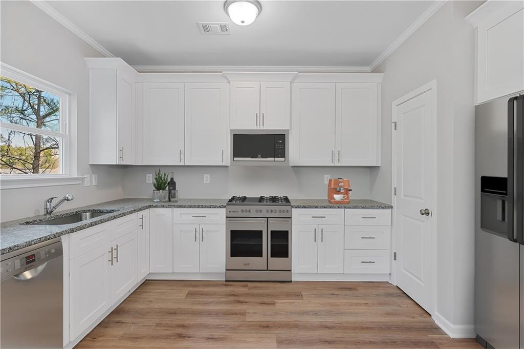 2832 Laurel Ridge Circle Atlanta, GA 30344 - Photo 13 of 28 a kitchen with stainless steel appliances granite countertop a stove and white cabinets