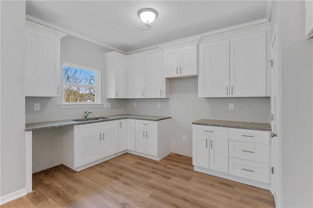 2832 Laurel Ridge Circle Atlanta, GA 30344 - Photo 9 of 28 a kitchen with granite countertop white cabinets and wooden floor