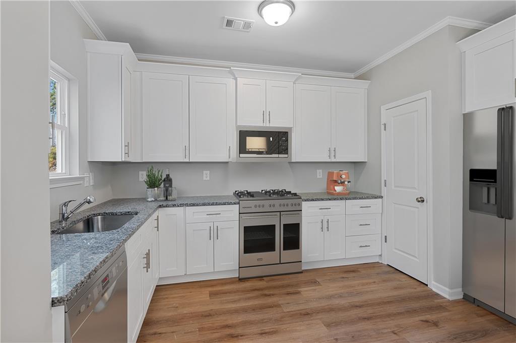 2832 Laurel Ridge Circle Atlanta, GA 30344 - Photo 10 of 28 a kitchen with granite countertop white cabinets and stainless steel appliances