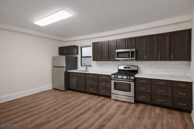 64 North 13th Street, Unit 2 Newark, NJ 07107 - Photo 2 of 16 a kitchen with stainless steel appliances granite countertop a stove a sink dishwasher a refrigerator and a microwave oven on the wooden floor