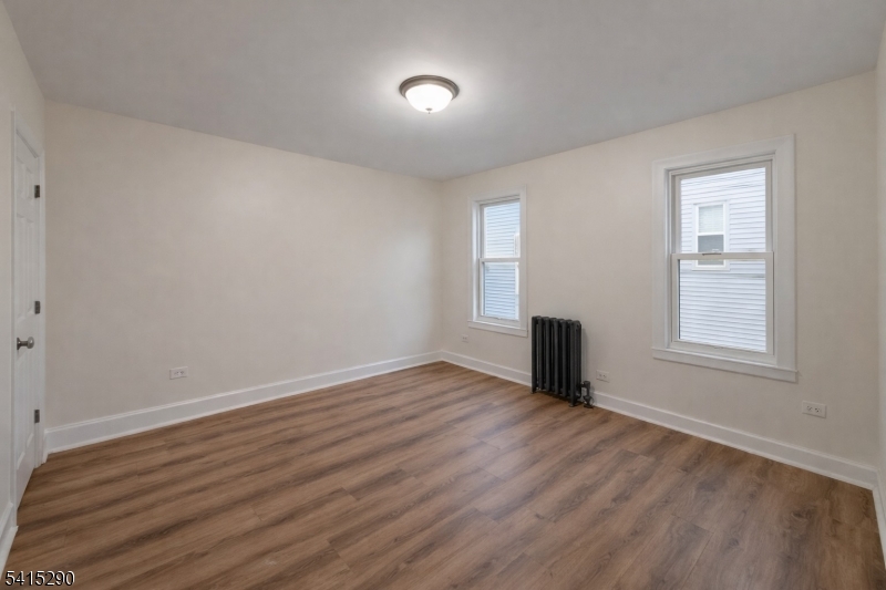 64 North 13th Street, Unit 2 Newark, NJ 07107 - Photo 9 of 16 an empty room with wooden floor and windows