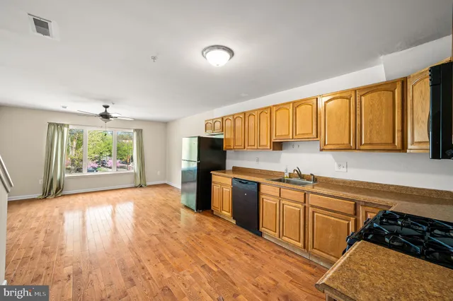 a kitchen with stainless steel appliances granite countertop a stove a sink dishwasher and a microwave oven with cabinets