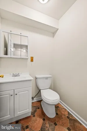 a bathroom with a toilet a sink and mirror