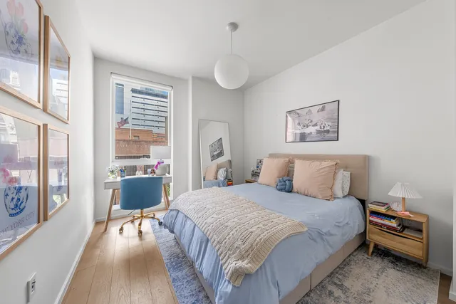 a bedroom with a bed and large window