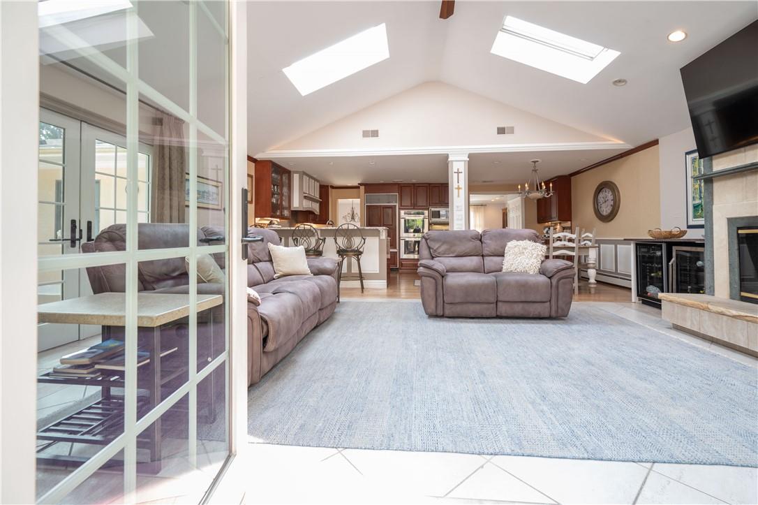 10 Wayacross Road Mahopac, NY 10541 - Photo 1 of 1 Living room featuring a baseboard heating unit, a skylight, a fireplace, high vaulted ceiling, and light tile patterned floors