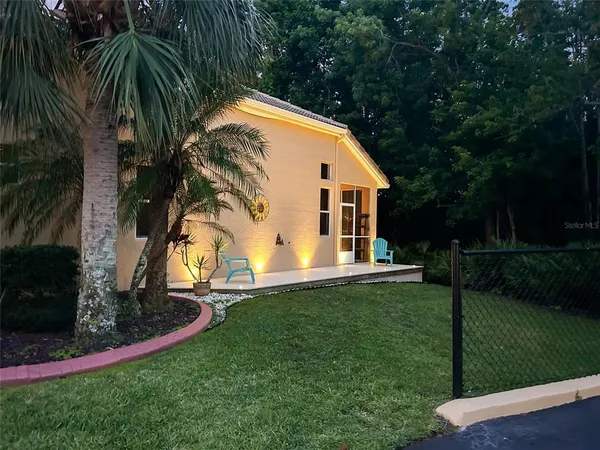 a view of a house with a big yard and large trees