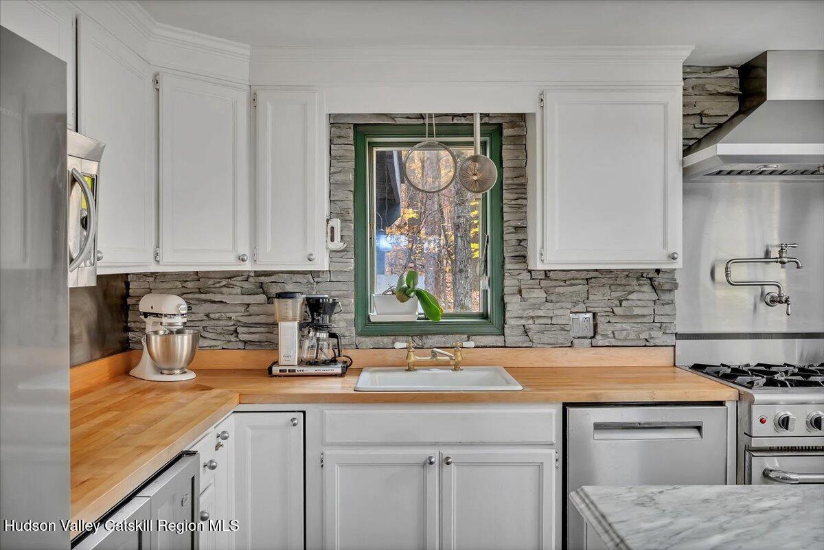 126 Storks Nest Road Round Top, NY 12473 - Photo 12 of 44 a kitchen with stainless steel appliances granite countertop a sink stove and cabinets
