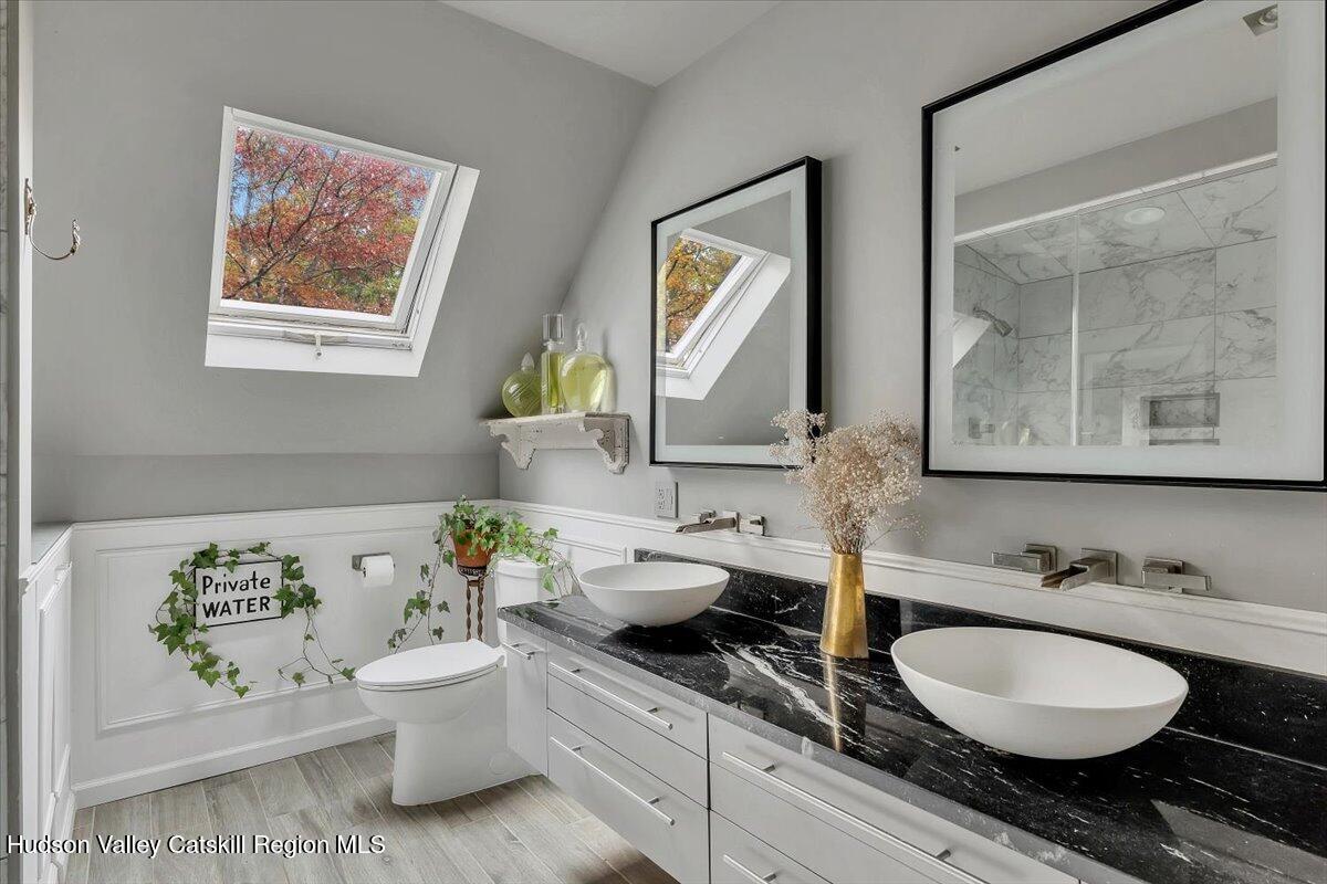 126 Storks Nest Road Round Top, NY 12473 - Photo 22 of 44 a bathroom with a granite countertop toilet sink and mirror