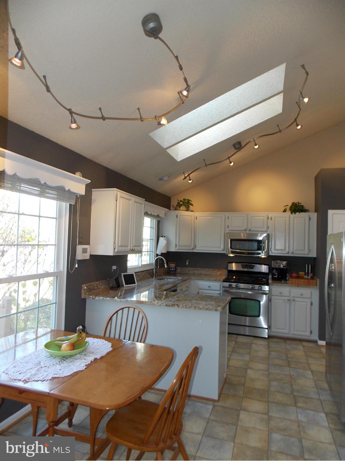 429 Deer Path Avenue Southwest Leesburg, VA 20175 - Photo 9 of 30 a kitchen with stainless steel appliances granite countertop a stove top oven a sink a dining table and chairs